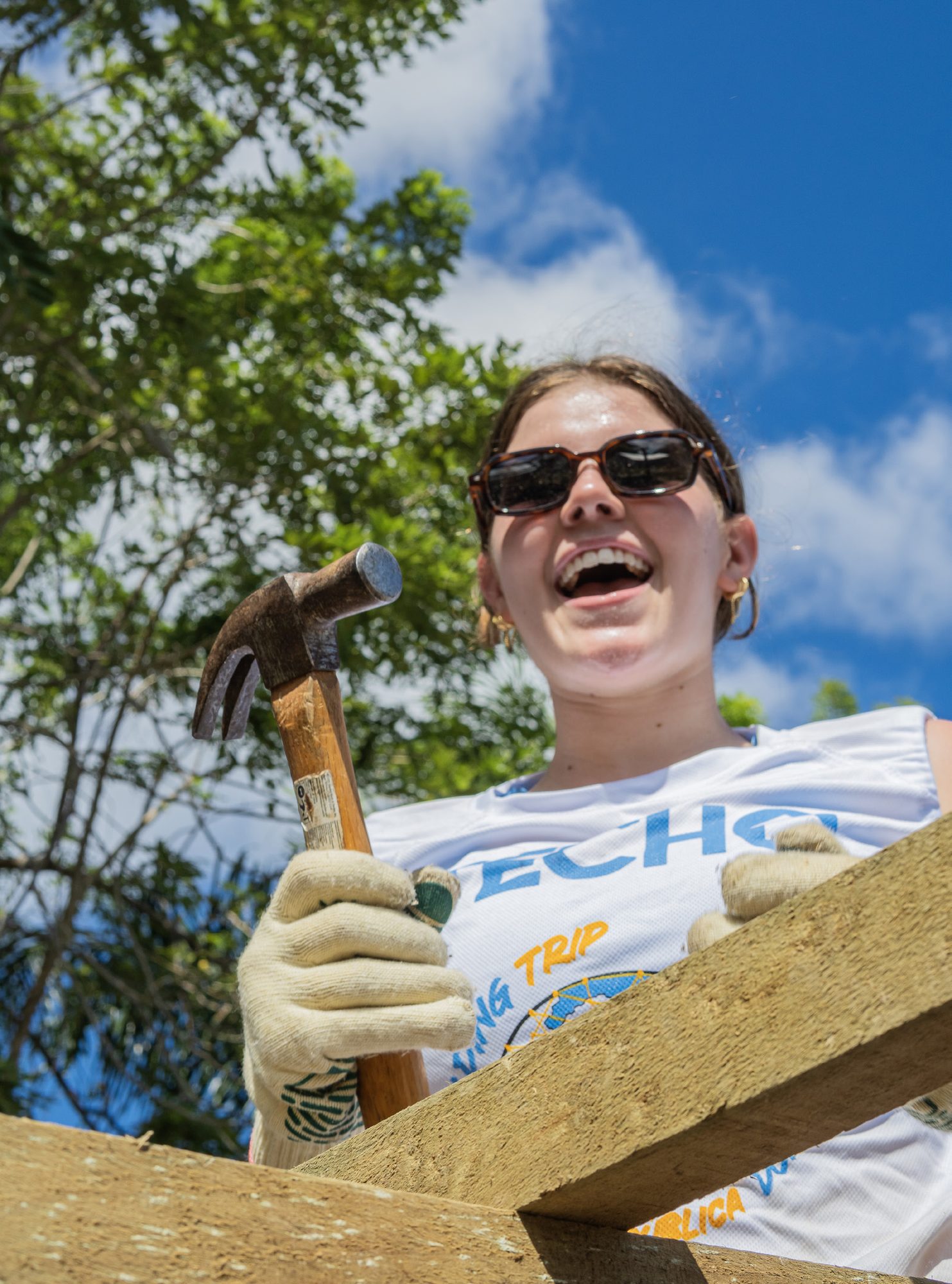 Voluntaria con martillo en alto contra el cielo